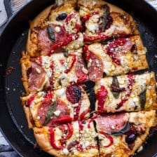 晒干番茄和橄榄香蒜沙司披萨配意大利腊肠和烤红辣椒。