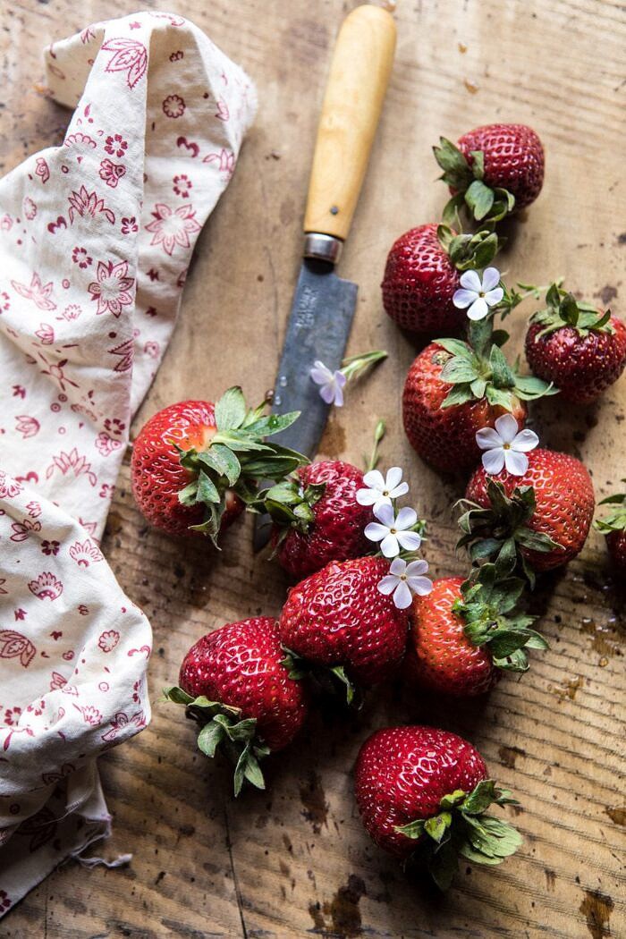 草莓顶上的照片与花和配对刀子的