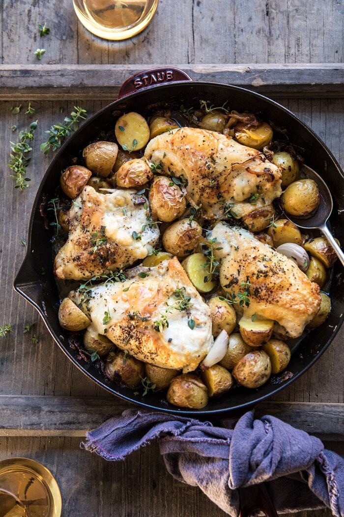 煎锅顶上的照片烤法国葱鸡和土豆用在桌上的酒