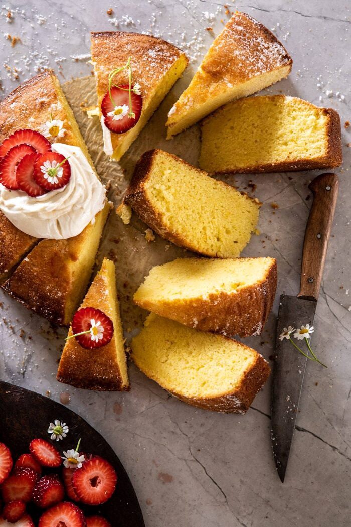 草莓洋甘菊橄榄油蛋糕与蜂蜜乳清干酪和8片切蛋糕和刀在照片