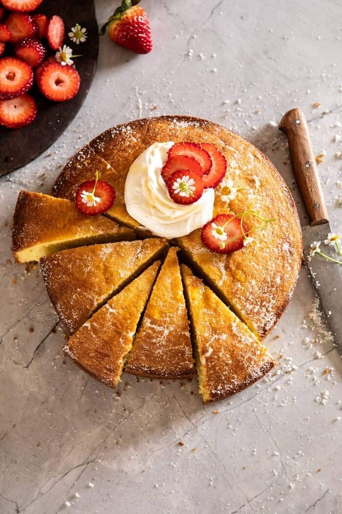 草莓洋甘菊橄榄油蛋糕与蜂蜜乳清干酪和6片切蛋糕的头顶照片