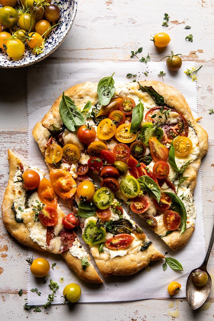 头顶照片的香草黄油传家宝番茄披萨与两块披萨切