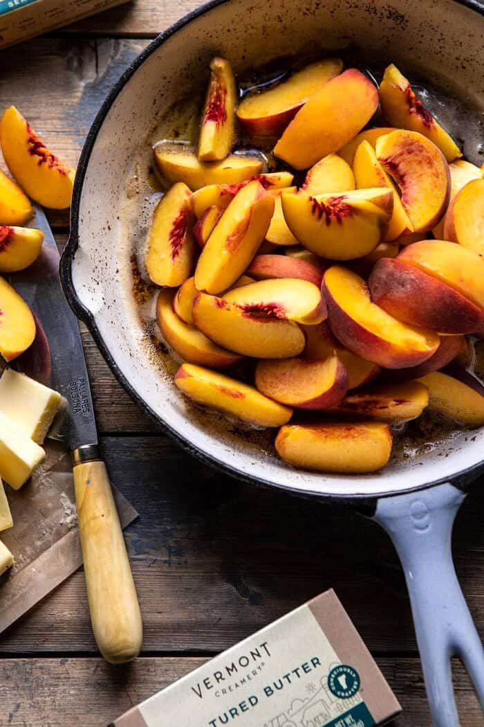 切的桃子的顶上的照片在煎锅的煎锅在烘烤前的褐红色的黄油