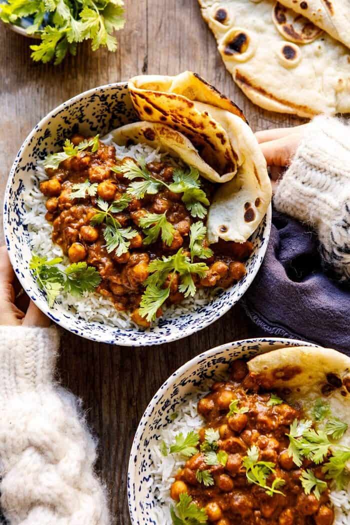 头顶上的照片，30分钟的印度南瓜黄油鹰嘴豆和手放在碗上