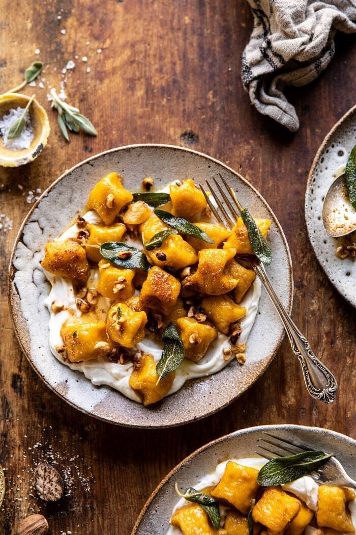 南瓜花椰菜Gnocchi顶上的照片与坚果褐色的黄油和鞭子的乳清干酪和叉子在碗