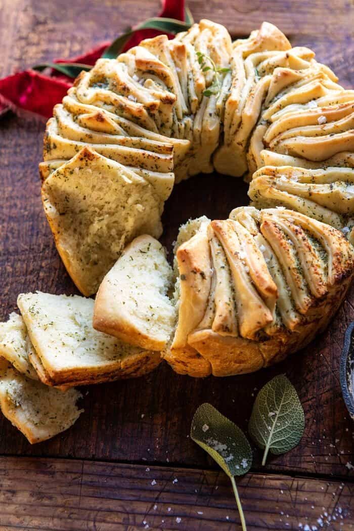 拉开的大蒜黄油面包花圈侧面角度的照片，其中几片拉开了面包