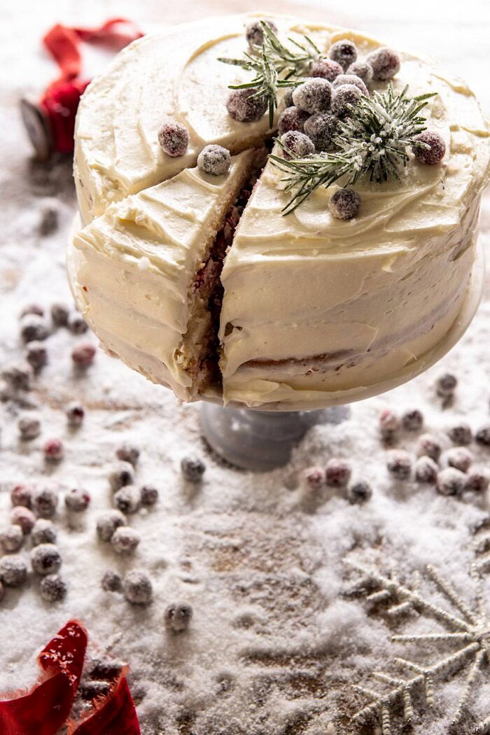 白色圣诞节蔓越桔层蛋糕旁边有角度的照片与1片切片的在蛋糕切开了