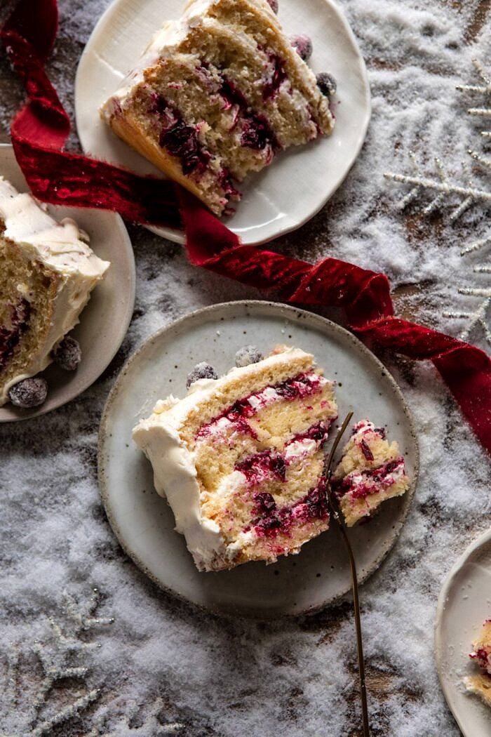 顶上的关闭白色圣诞节蔓越桔层数蛋糕切片与叉子的照片与在蛋糕切片