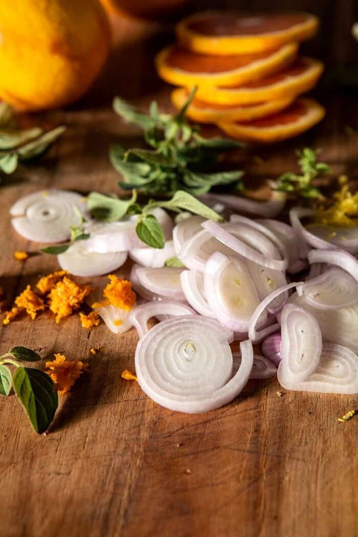 切菜板上放葱和柑橘，配香草