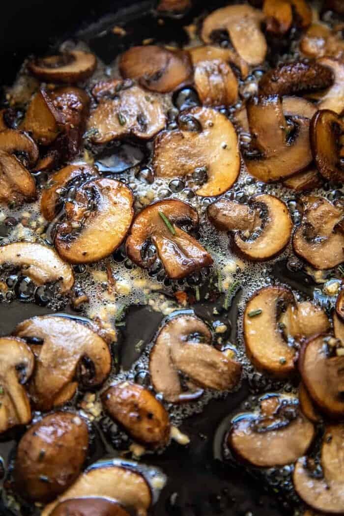 迷迭香黄油蘑菇烹饪的照片
